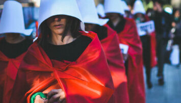 protesters march dressed as Handmaids.