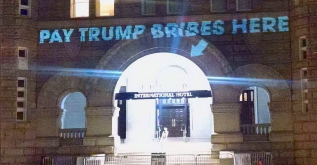 A Trump Hotel with a "Pay Trump Bribes Here" sign on it