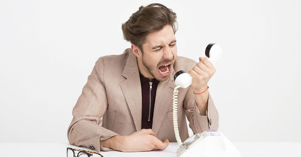 Man yelling into a telephone