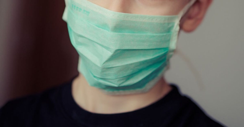 Close up photo of a person wearing a medical face mask