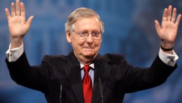 Mitch McConnell with his hands in the air