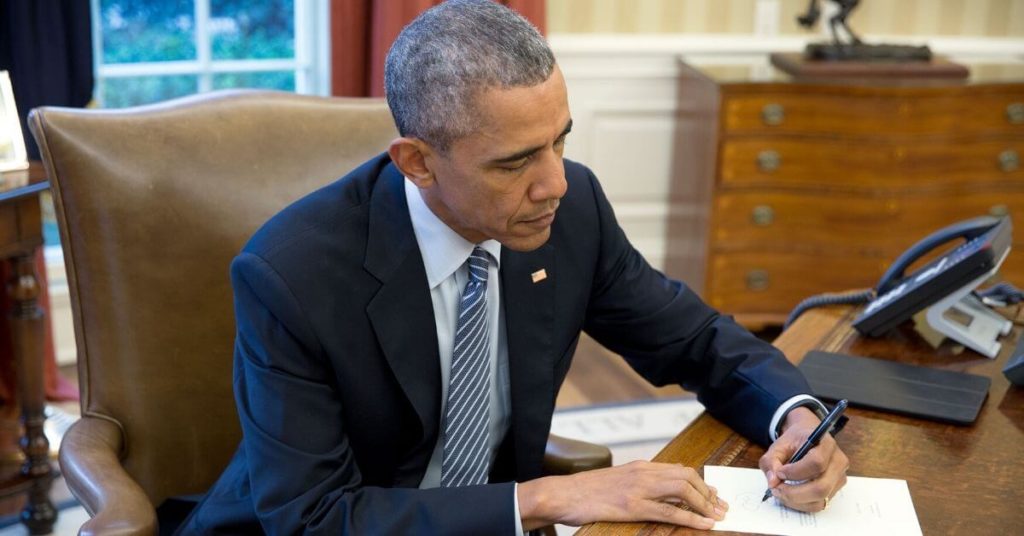 Obama sitting at his desk