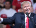 A photograph of Donald Trump on a rally platform smiling and pointing.