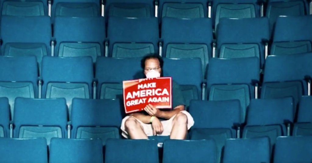 A photograph of a single Trump supporter sitting alone in arena seats.