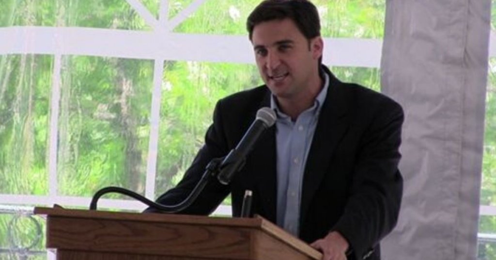 Aaron Zelinsky standing behind a podium