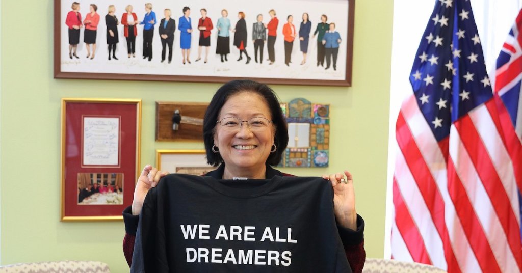 A photograph of Hawaii Senator Mazie Hirono holding up a We Are All Dreamers t-shirt.
