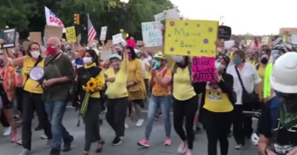 Moms demonstrating in yellow shirts