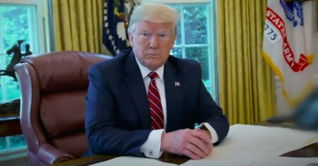 Trump sitting at his desk